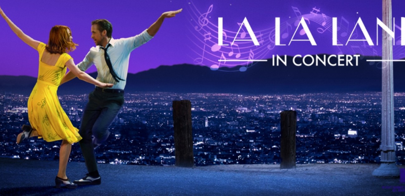 Dancers in a vibrant cityscape for La La Land In Concert show, with musical notes on a purple night sky.