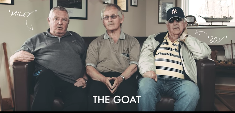 Three older men sit on a couch labeled THE GOAT, with nicknames Miley and Boy shown by arrows.