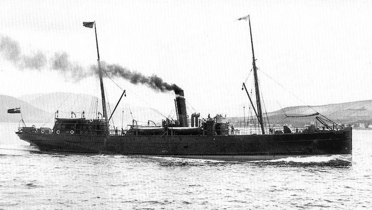 Vintage steamship sailing in open waters, emitting smoke, with distant hills in the background.
