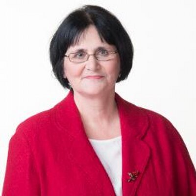 Woman in red suit posing against a white background.